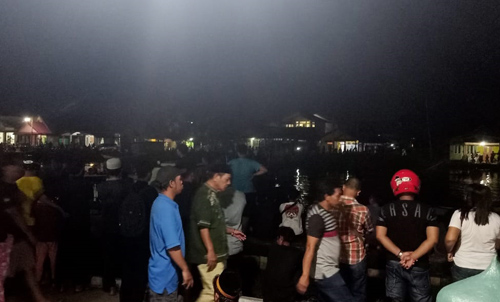 Warga berkerumun di tepian Sungai Muare Ulakan Sambas menunggu hasil pencarian korban tenggelam, Rabu malam (27/7/2022) di Sungai Sambas