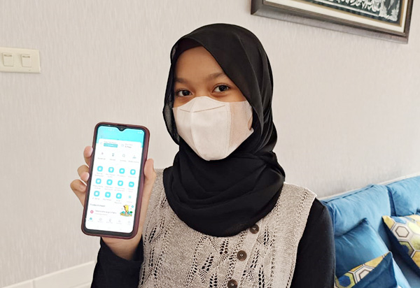 Asmawati, salah seorang warga Singkawang menunjukkan aplikasi PLN Mobile di android miliknya.