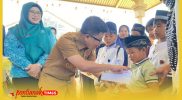 Bupati Sambas H. Satono didampingi Ketua TP PKK Kabupaten Sambas Hj. Yunisa menyerahkan santunan kepada peserta khitanan massal.