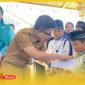 Bupati Sambas H. Satono didampingi Ketua TP PKK Kabupaten Sambas Hj. Yunisa menyerahkan santunan kepada peserta khitanan massal. 