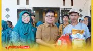 Bupati Sambas H. Satono didampingi Ketua TP PKK Hj Yunisa menyerahkan secara simbolis Sembako dalam .program Gerakan Pangan Murah