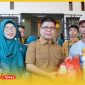 Bupati Sambas H. Satono didampingi Ketua TP PKK Hj Yunisa menyerahkan secara simbolis Sembako dalam .program Gerakan Pangan Murah