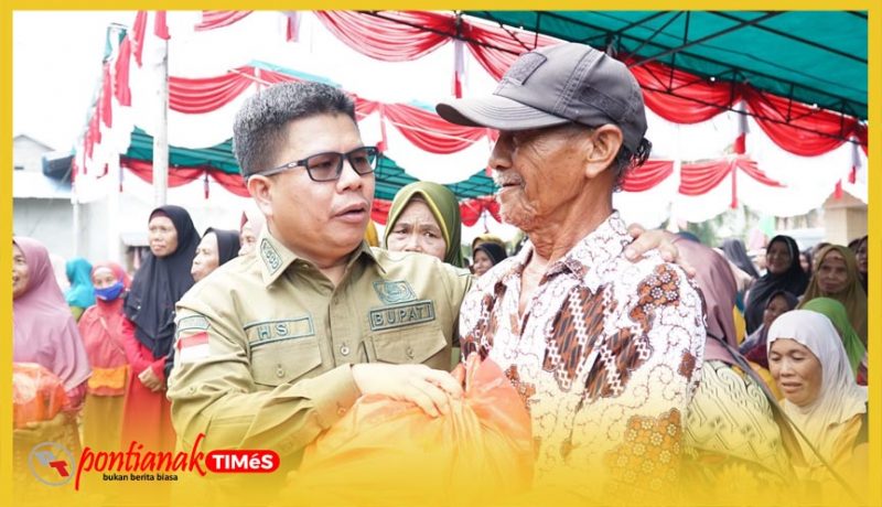 Bupati Sambas, H. Satono menyapa ramah warga pada pembagian paket sembako gratis dalam kegiatan Pasar Murah Kecamatan Tangaran, Senin (19/10/2026).